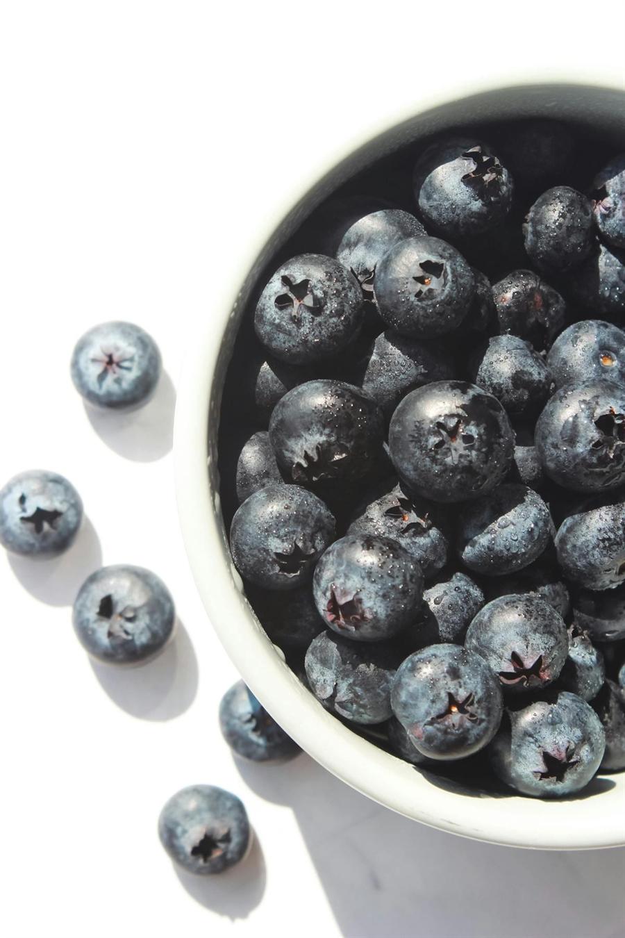 Blueberries in a white bowl on a light background