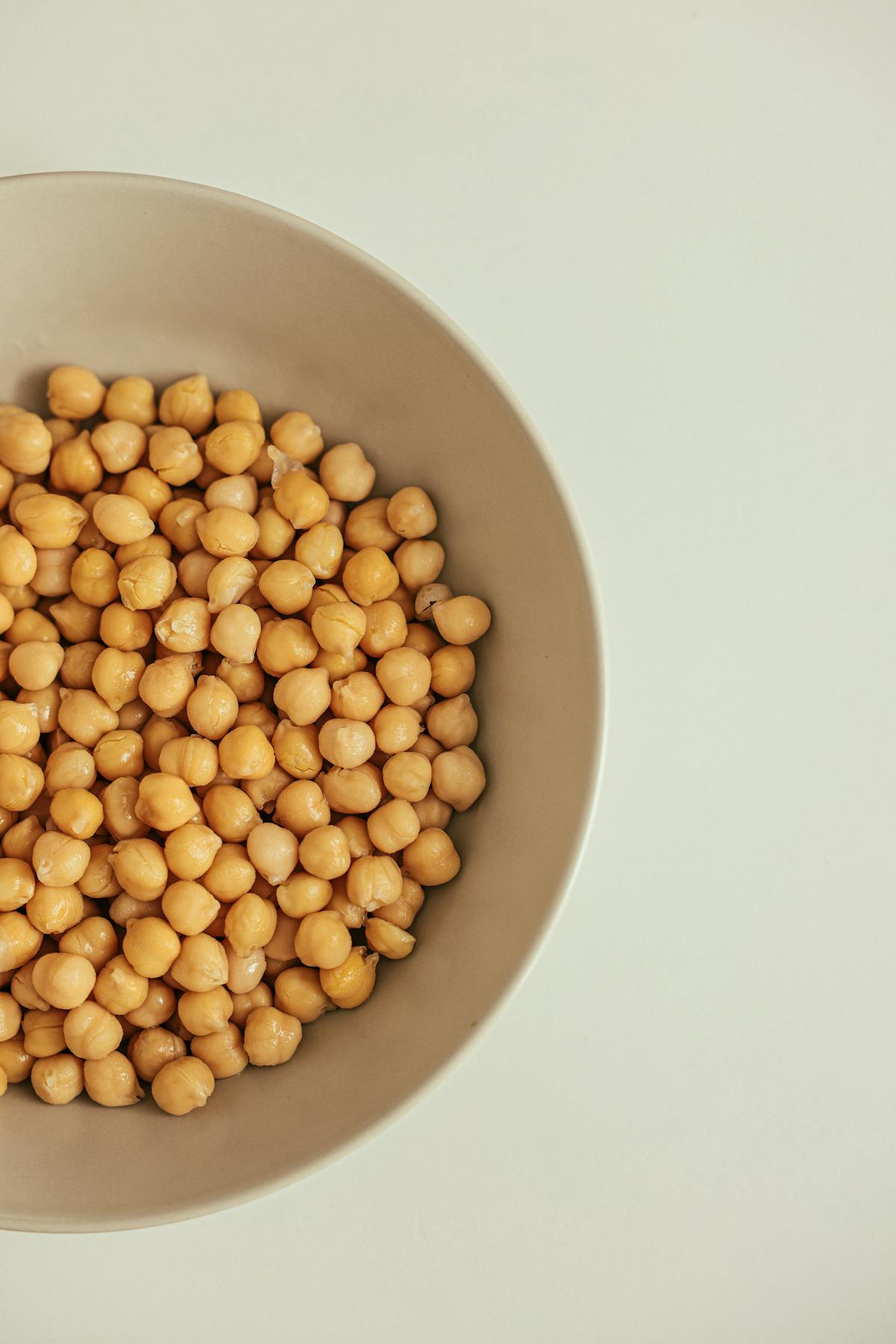 Cooked chickpeas in a bowl on a light background