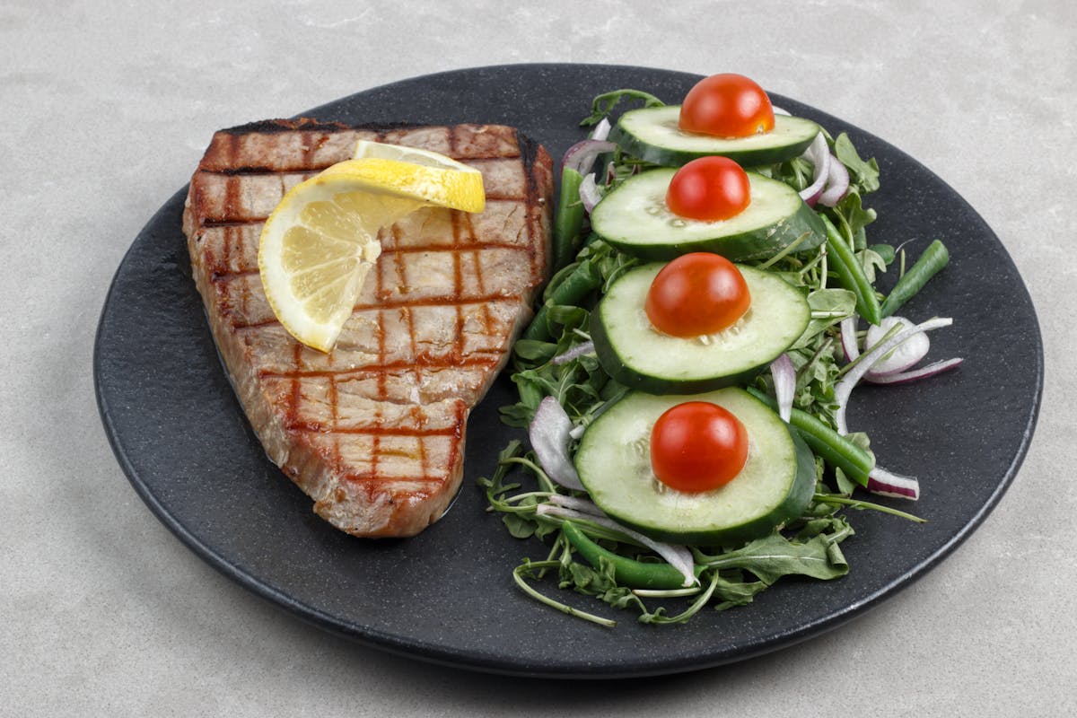 Grilled tuna steak with lemon and salad