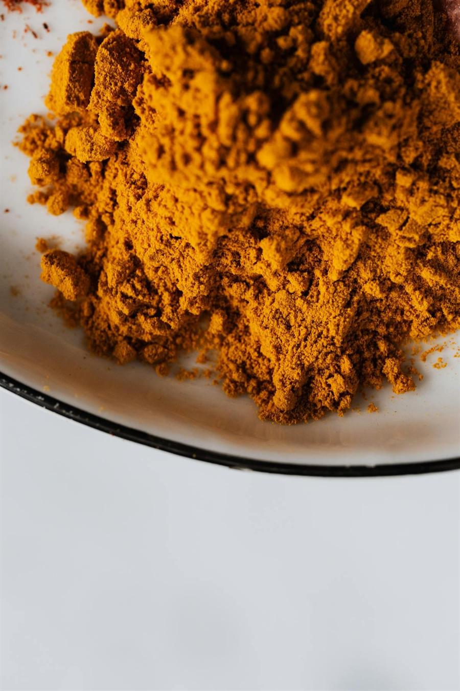 Turmeric root and powder on a light background